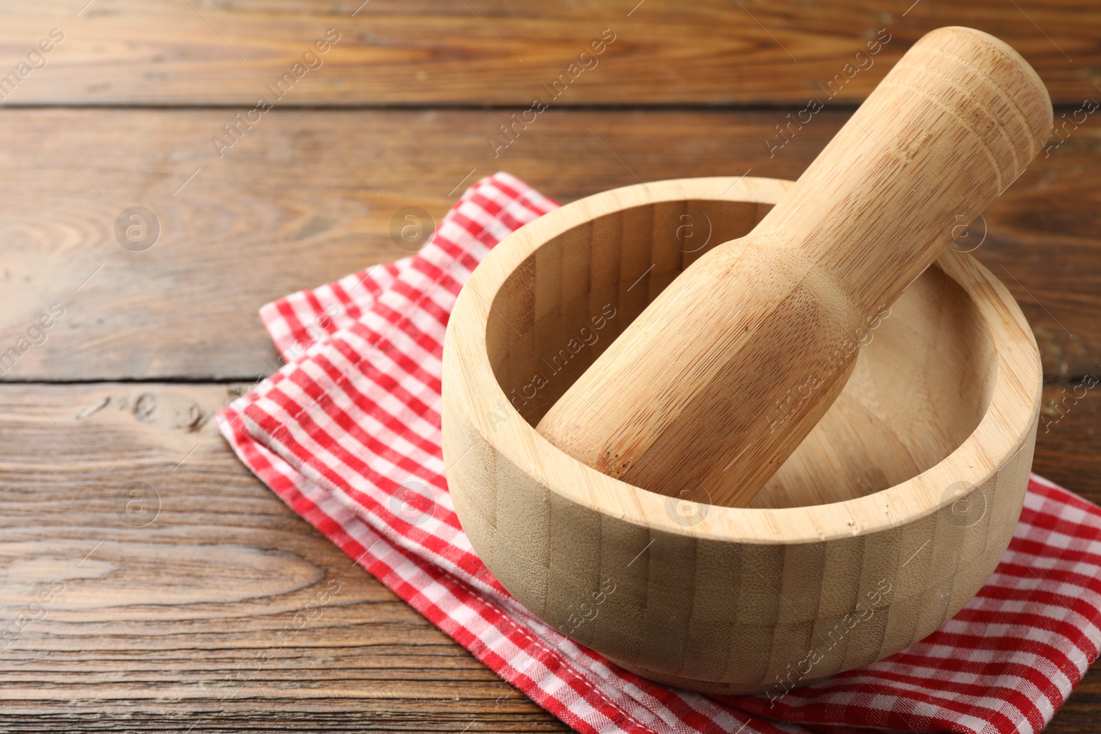 Mortar, pestle and cloth on wooden table, closeup Photo of Mortar, pestle and cloth on wooden table, closeup