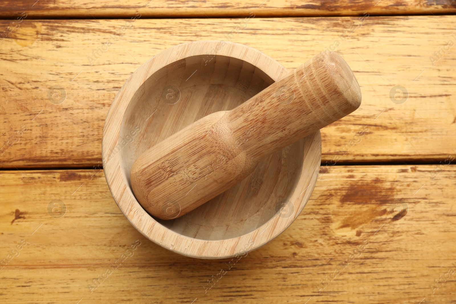 Mortar and pestle on wooden table, top view Photo of Mortar and pestle on wooden table, top view