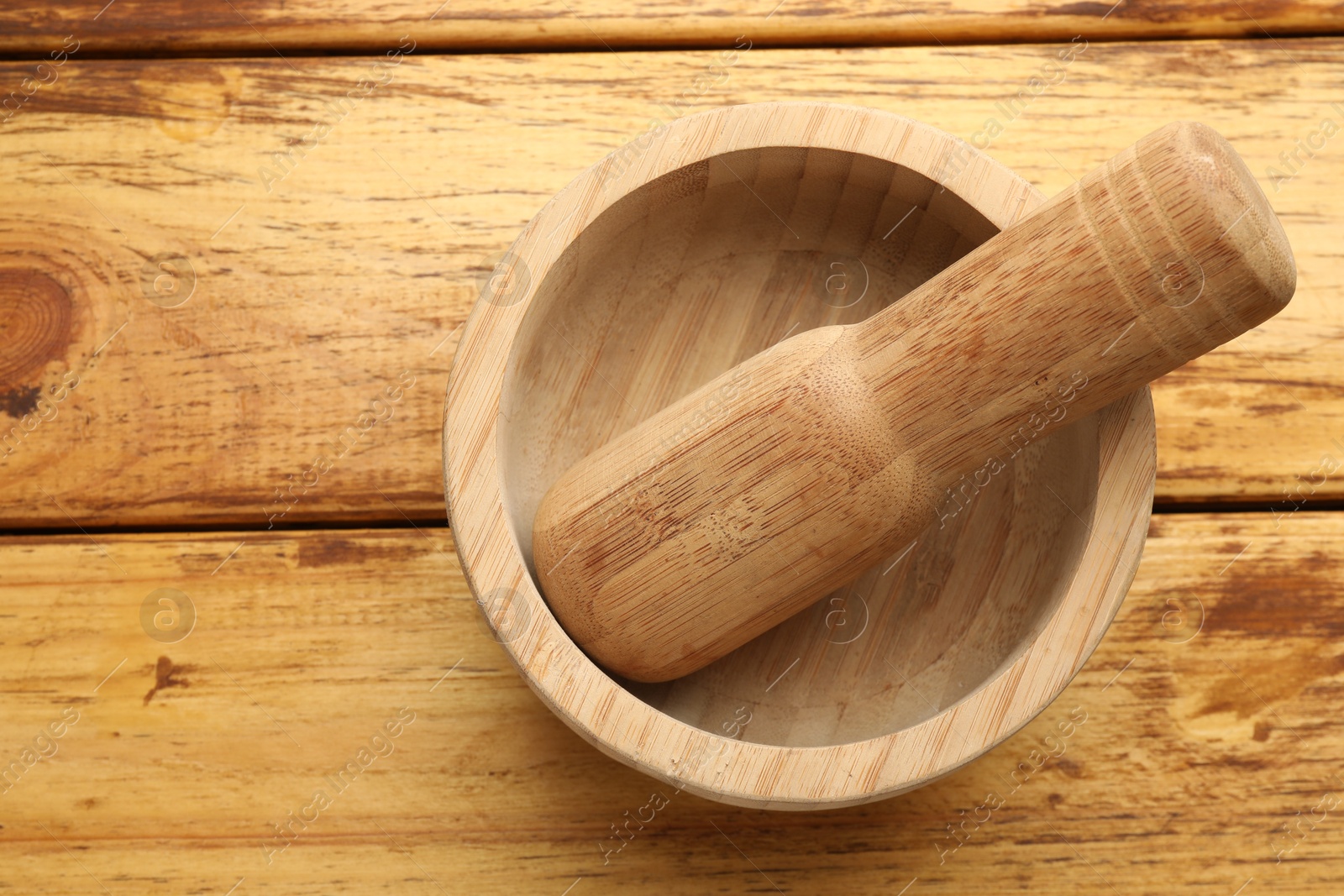 Mortar and pestle on wooden table, top view Photo of Mortar and pestle on wooden table, top view