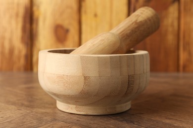 Photo of Mortar and pestle on wooden table, closeup