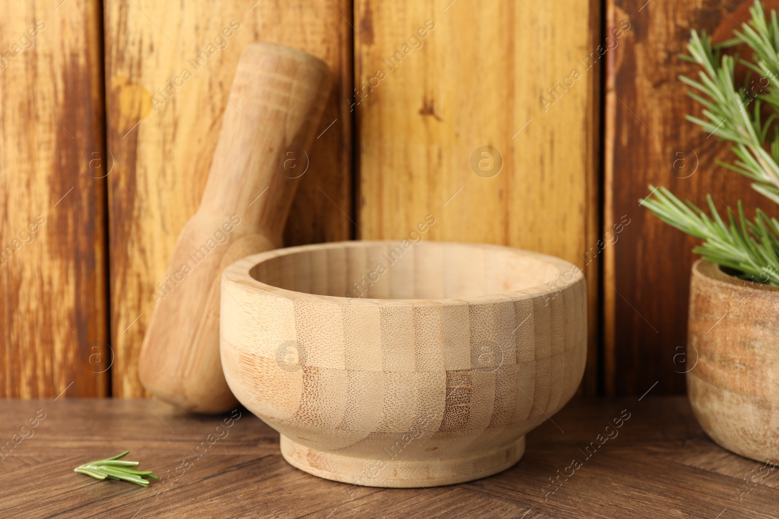 Mortar with rosemary and pestle on wooden table, closeup Photo of Mortar with rosemary and pestle on wooden table, closeup