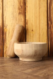 Photo of Mortar and pestle on wooden table. Cooking utensil
