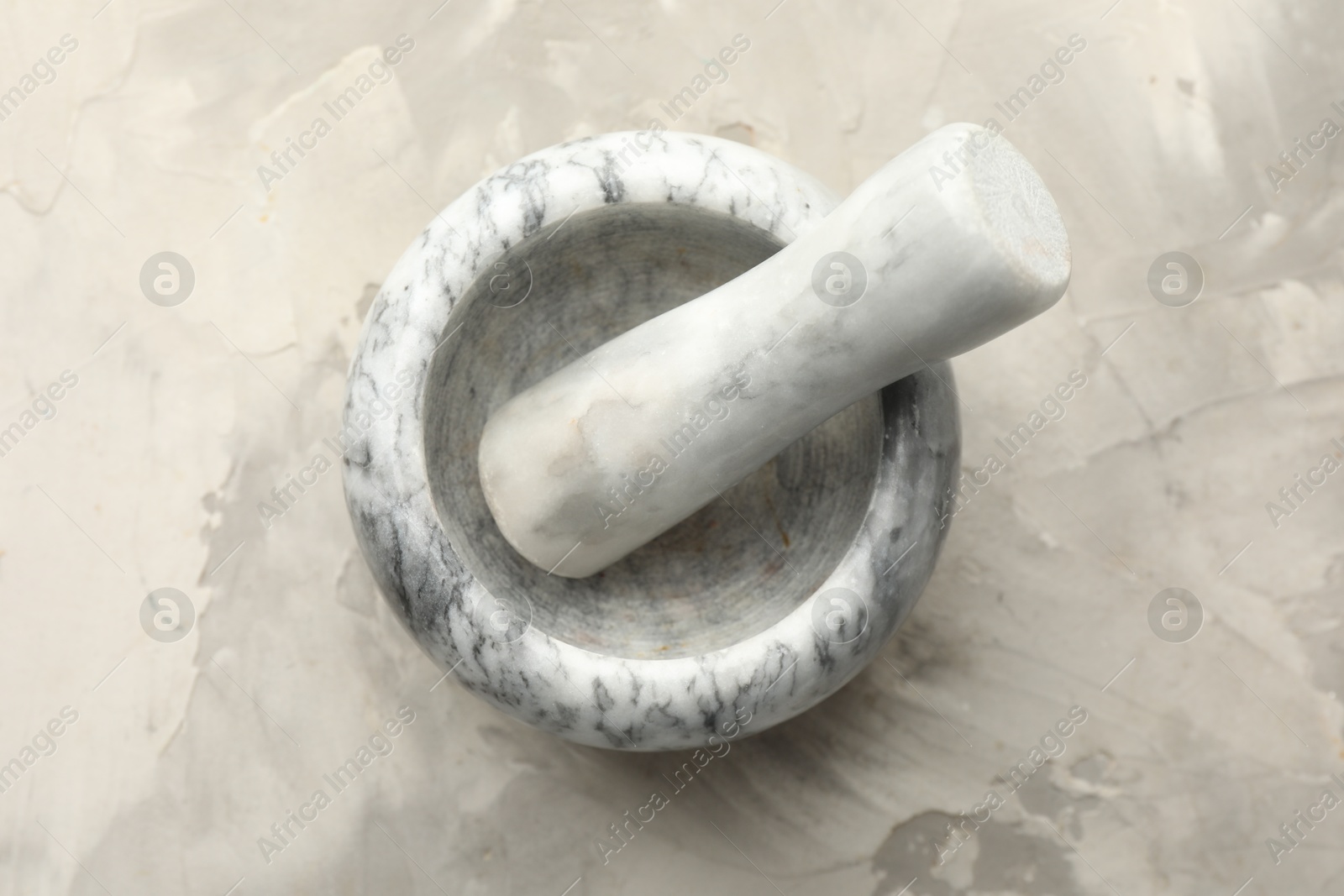 Marble mortar and pestle on grey textured table, top view Photo of Marble mortar and pestle on grey textured table, top view
