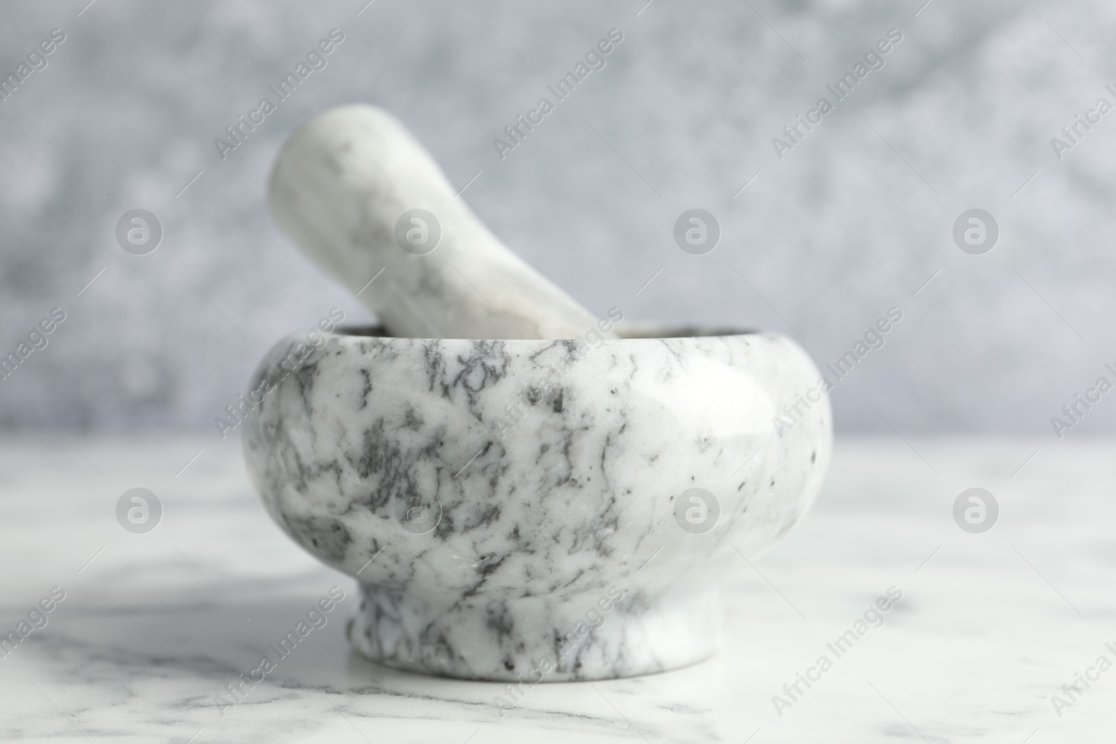 Mortar and pestle on white marble table, closeup Photo of Mortar and pestle on white marble table, closeup