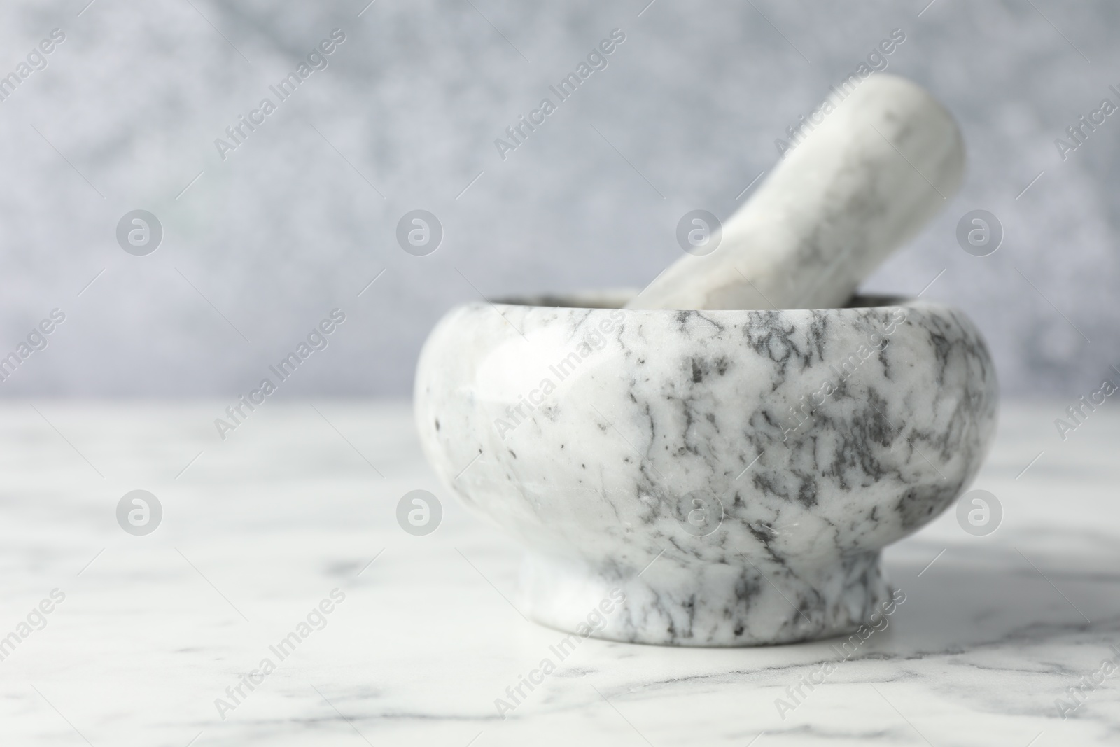 Mortar and pestle on white marble table, closeup Photo of Mortar and pestle on white marble table, closeup
