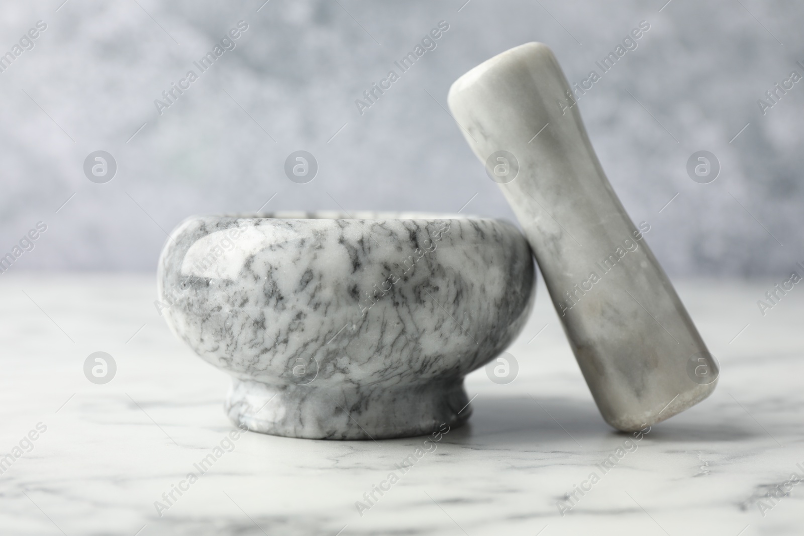 Mortar and pestle on white marble table, closeup Photo of Mortar and pestle on white marble table, closeup