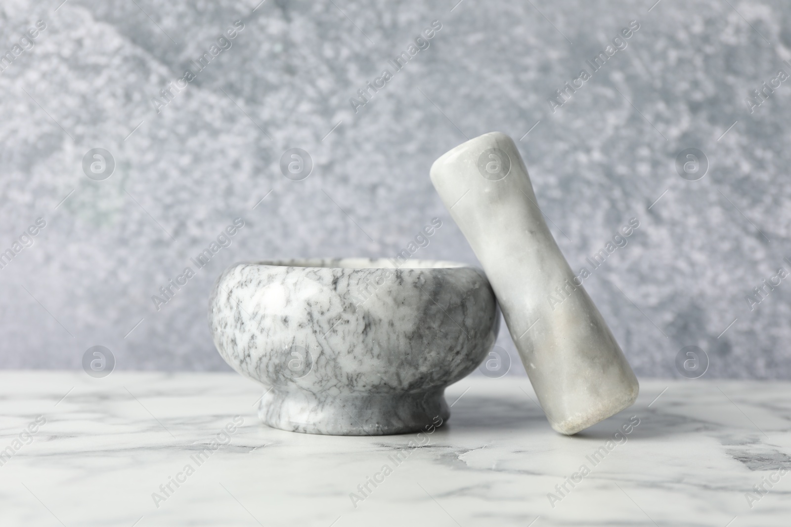 Mortar and pestle on white marble table, closeup Photo of Mortar and pestle on white marble table, closeup