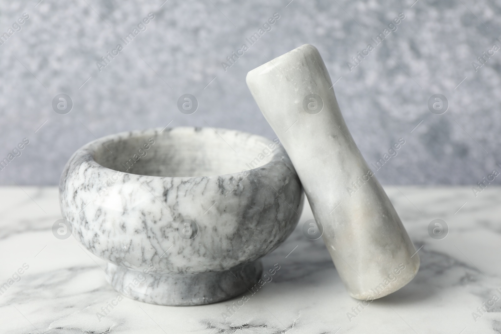 Mortar and pestle on white marble table, closeup Photo of Mortar and pestle on white marble table, closeup