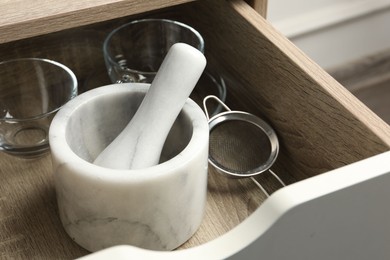 Photo of Marble mortar and pestle in drawer indoors, closeup