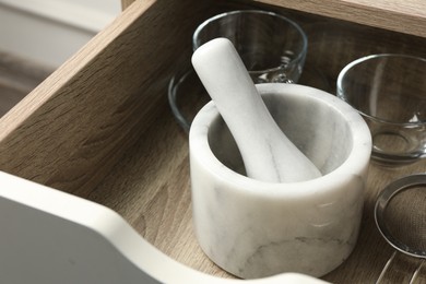 Photo of Marble mortar and pestle in drawer indoors, closeup