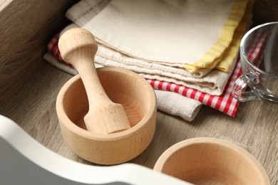 Photo of Wooden mortar and pestle in drawer indoors, closeup