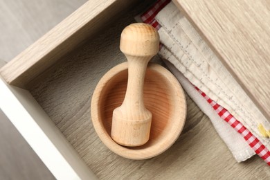 Photo of Wooden mortar and pestle in drawer indoors, top view