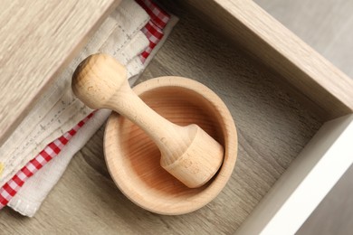 Photo of Wooden mortar and pestle in drawer indoors, top view