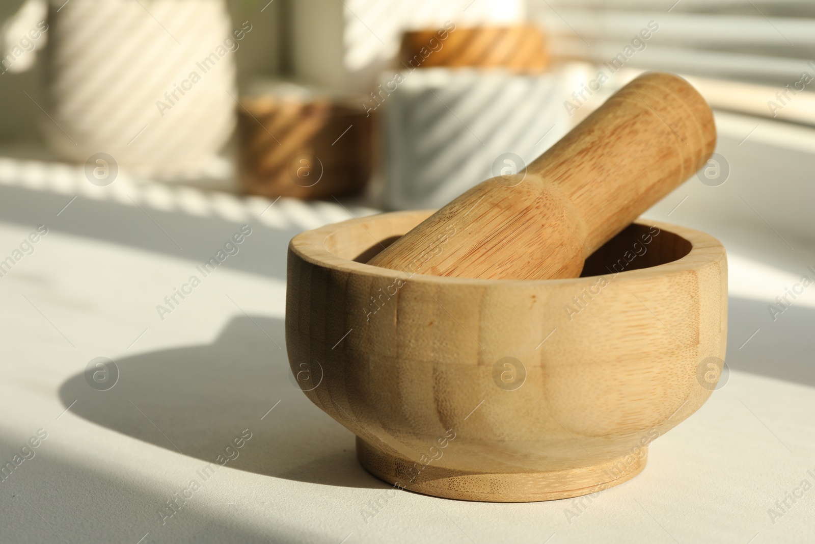 Wooden mortar and pestle on windowsill indoors, closeup Photo of Wooden mortar and pestle on windowsill indoors, closeup