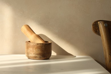 Photo of Wooden mortar and pestle on white table indoors