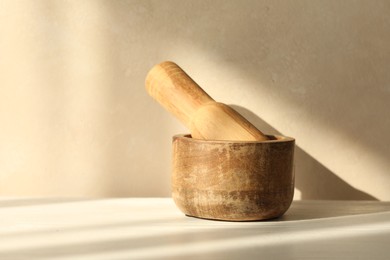 Photo of Wooden mortar and pestle on white table indoors