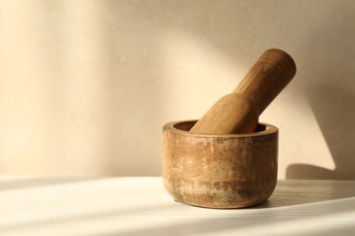 Photo of Wooden mortar and pestle on white table indoors