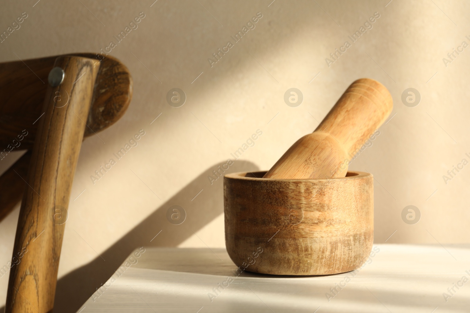 Wooden mortar and pestle on white table indoors, closeup Photo of Wooden mortar and pestle on white table indoors, closeup