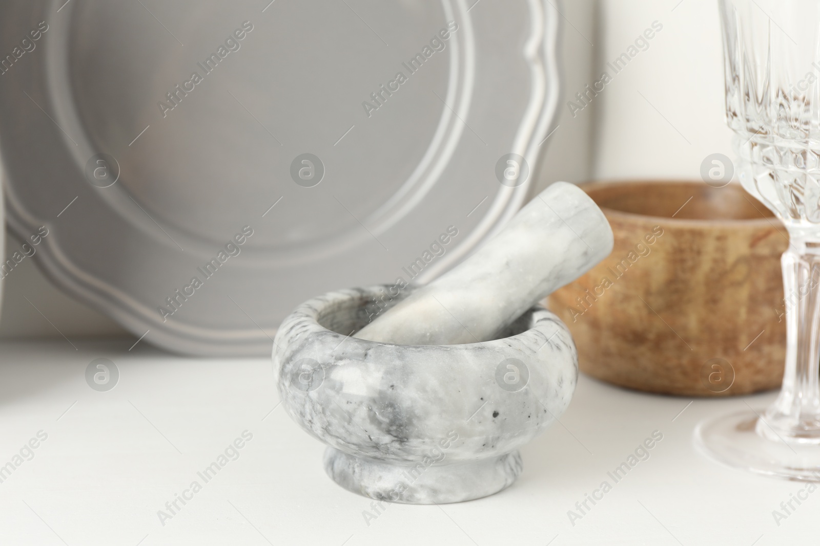 Marble mortar and pestle on white table indoors, closeup Photo of Marble mortar and pestle on white table indoors, closeup