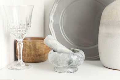 Photo of Marble mortar and pestle on white table indoors, closeup