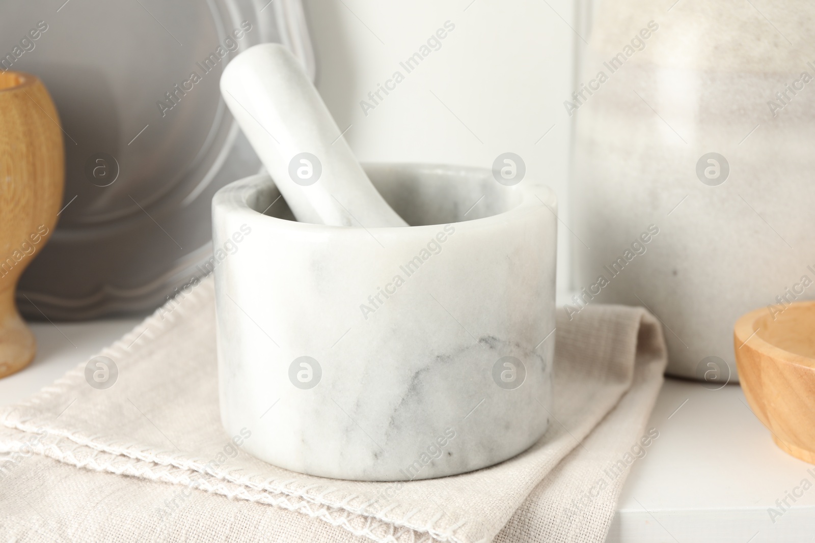 Marble mortar and pestle on white table indoors, closeup Photo of Marble mortar and pestle on white table indoors, closeup