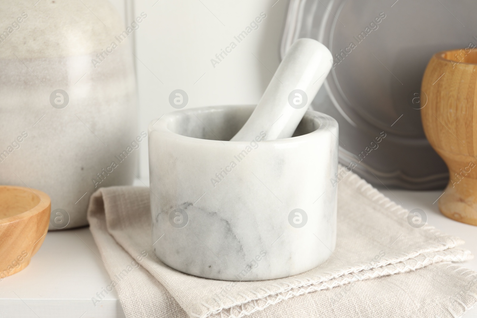Marble mortar and pestle on white table indoors, closeup Photo of Marble mortar and pestle on white table indoors, closeup
