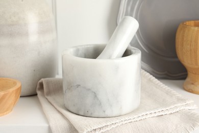 Photo of Marble mortar and pestle on white table indoors, closeup