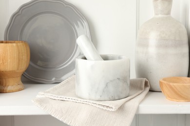 Photo of Marble mortar and pestle on white table indoors, closeup