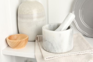 Photo of Marble mortar and pestle on white table indoors, closeup