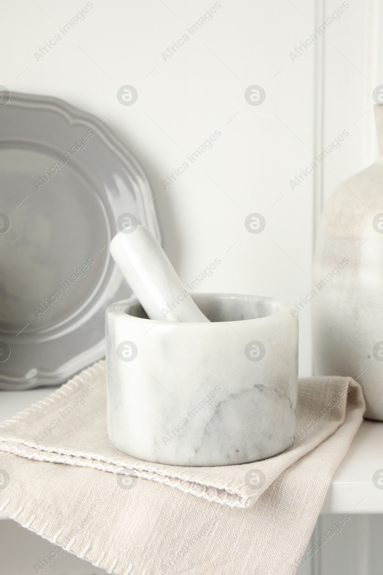 Marble mortar and pestle on white table indoors, closeup Photo of Marble mortar and pestle on white table indoors, closeup