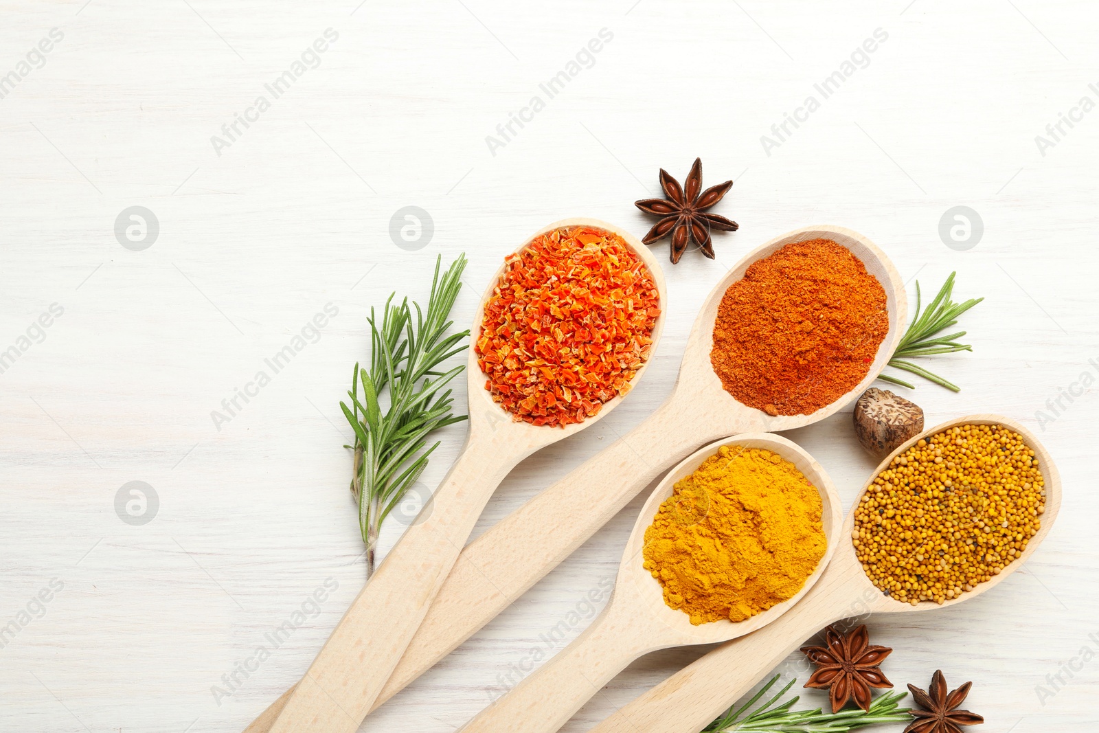 Different aromatic spices in spoons on white wooden table, flat lay. Space for text Photo of Different aromatic spices in spoons on white wooden table, flat lay. Space for text