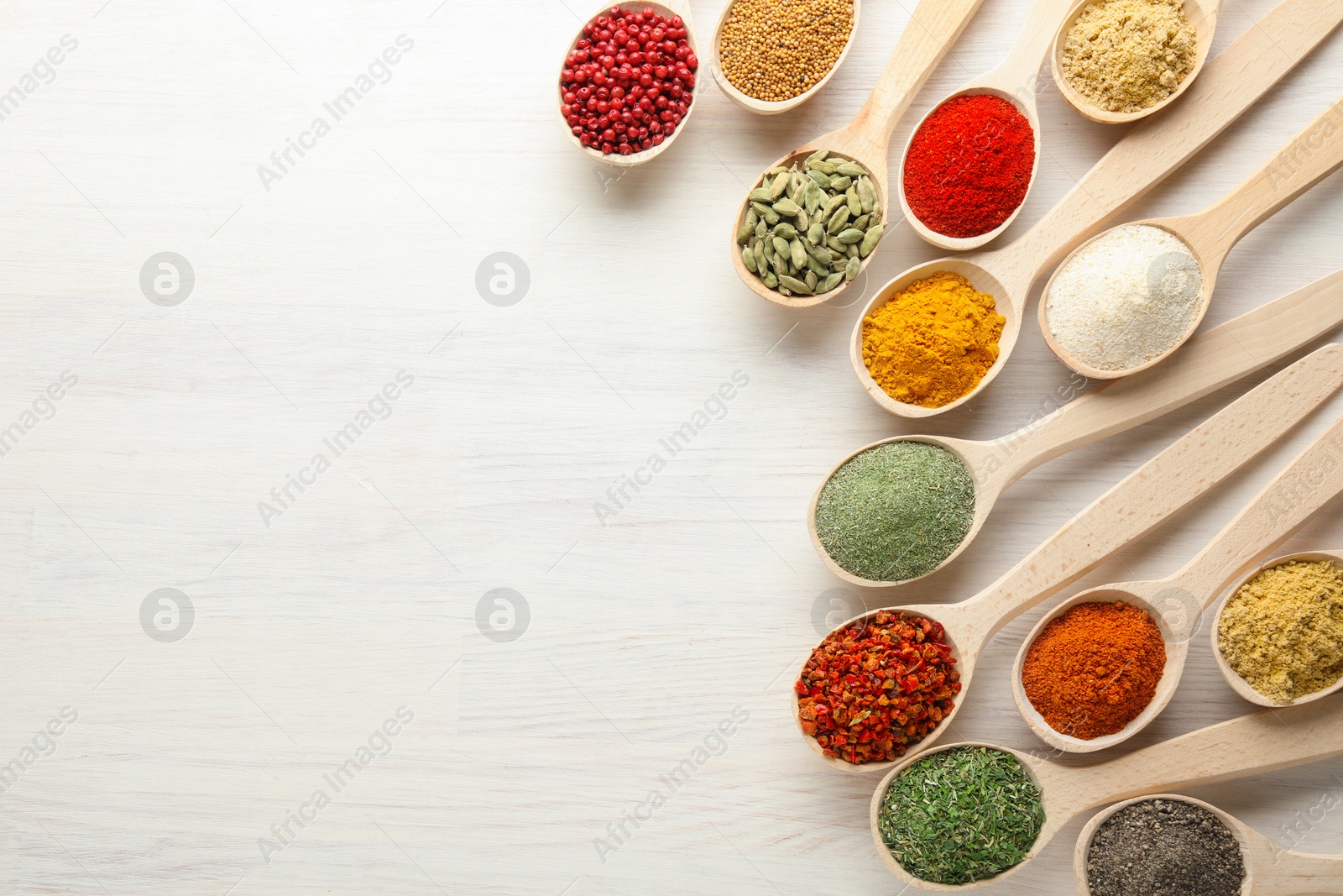 Different aromatic spices in spoons on white wooden table, flat lay. Space for text Photo of Different aromatic spices in spoons on white wooden table, flat lay. Space for text
