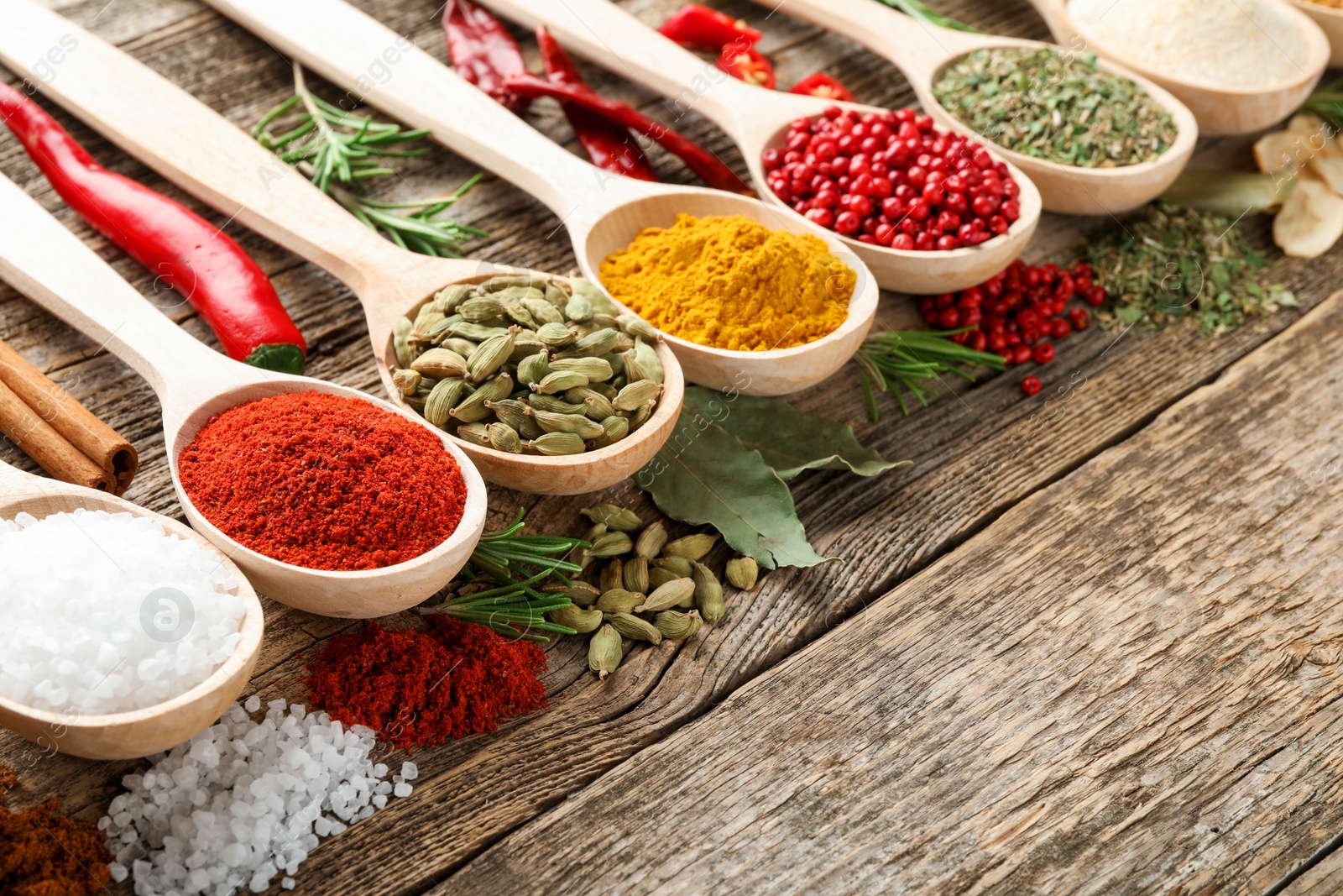 Different aromatic spices in spoons on wooden table, closeup Photo of Different aromatic spices in spoons on wooden table, closeup