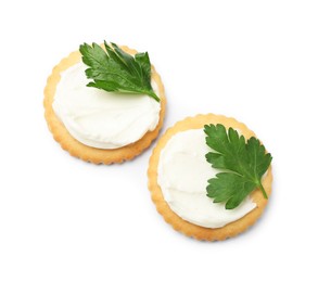 Photo of Tasty crackers with cream cheese and parsley isolated on white, top view