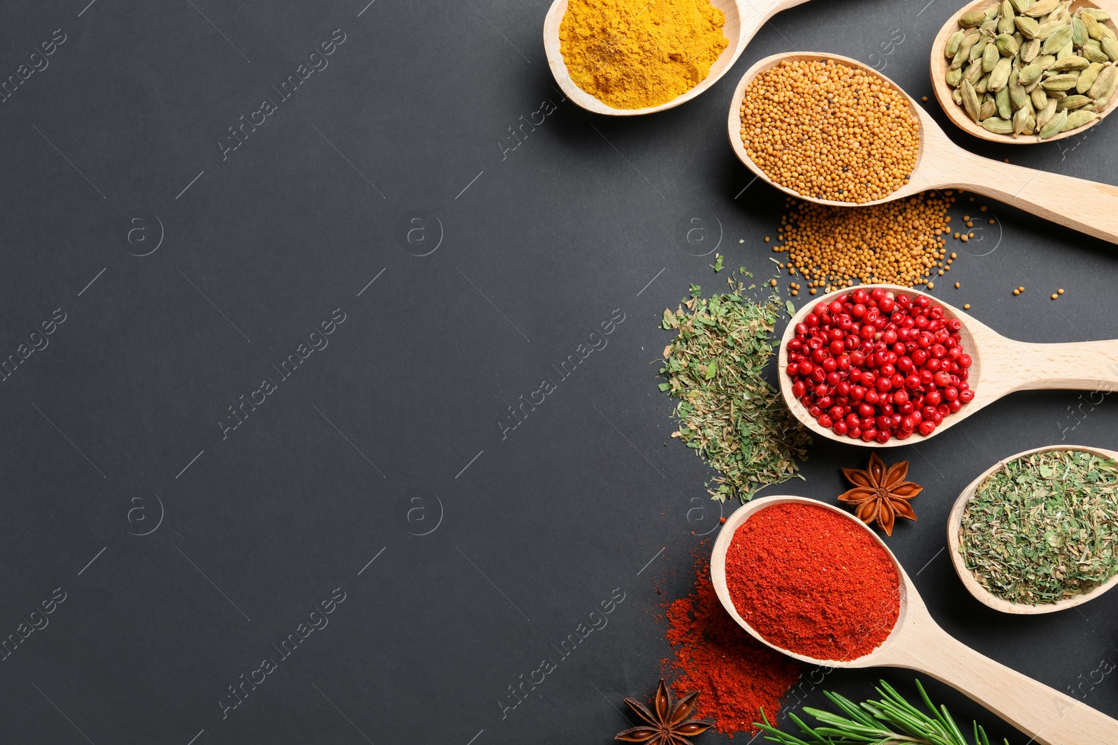 Different aromatic spices in spoons on black table, flat lay. Space for text Photo of Different aromatic spices in spoons on black table, flat lay. Space for text