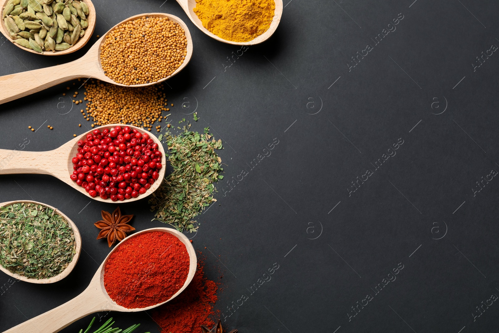 Different aromatic spices in spoons on black table, flat lay. Space for text Photo of Different aromatic spices in spoons on black table, flat lay. Space for text