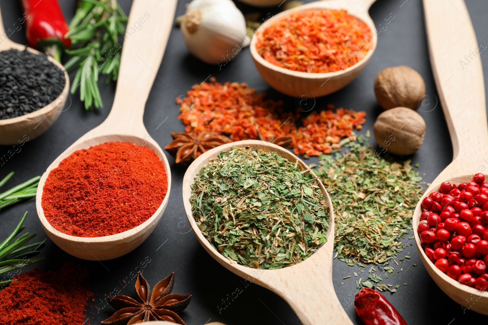 Different aromatic spices in spoons on black table, closeup Photo of Different aromatic spices in spoons on black table, closeup