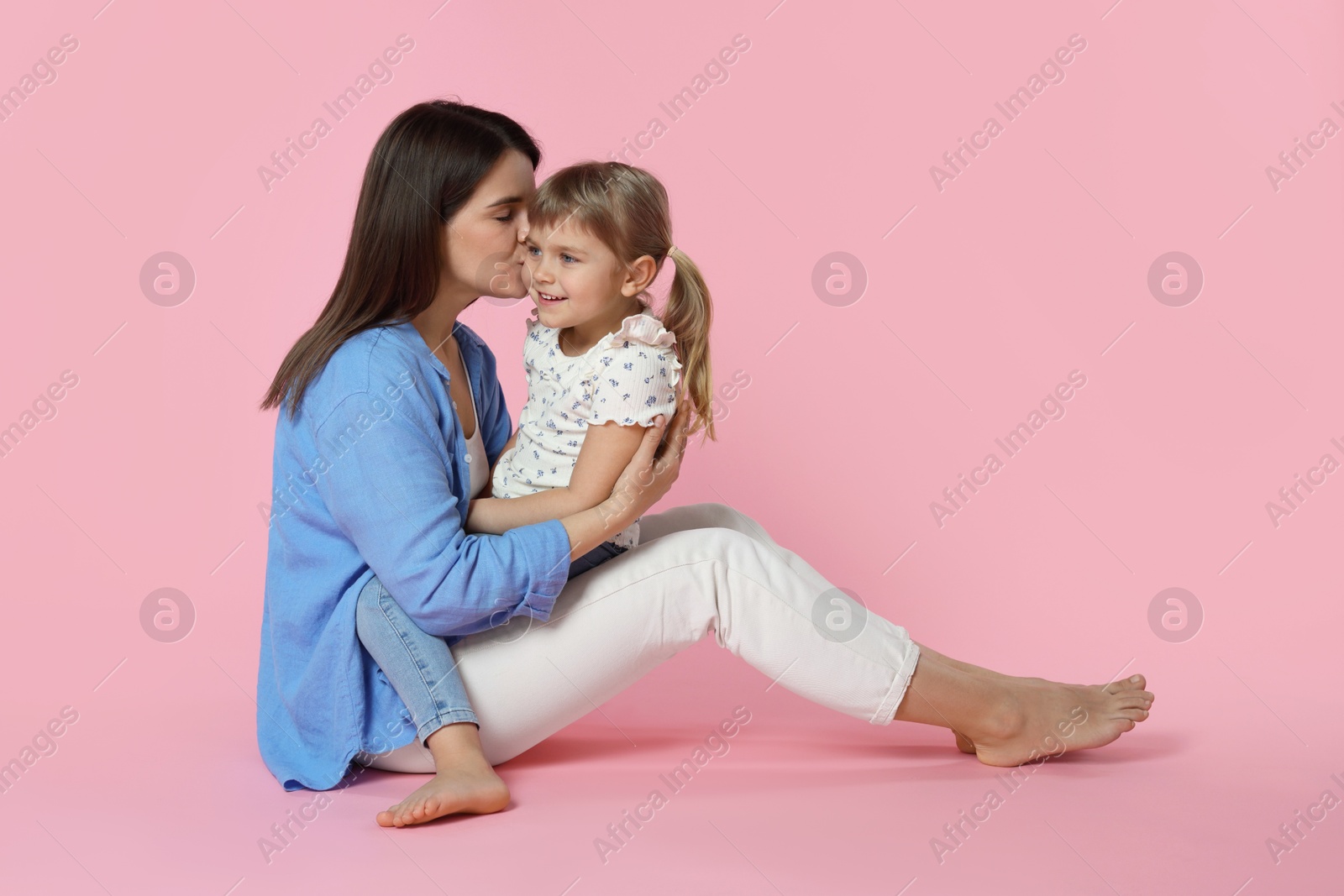 Photo of Happy mother and her cute daughter on pink background