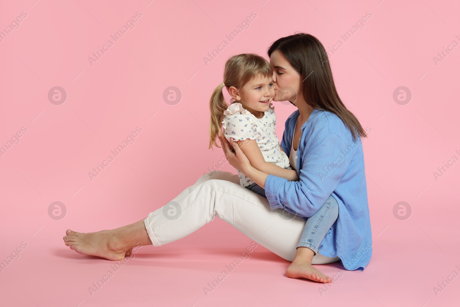 Photo of Happy mother and her cute daughter on pink background