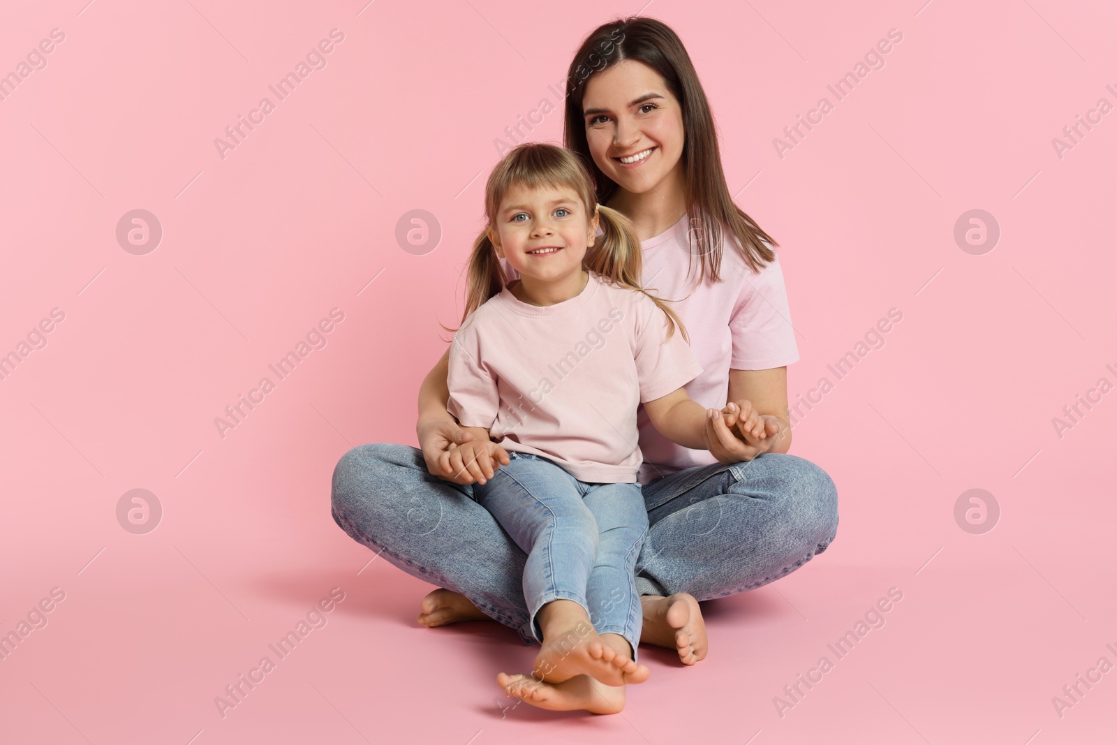 Photo of Happy mother and her cute daughter on pink background