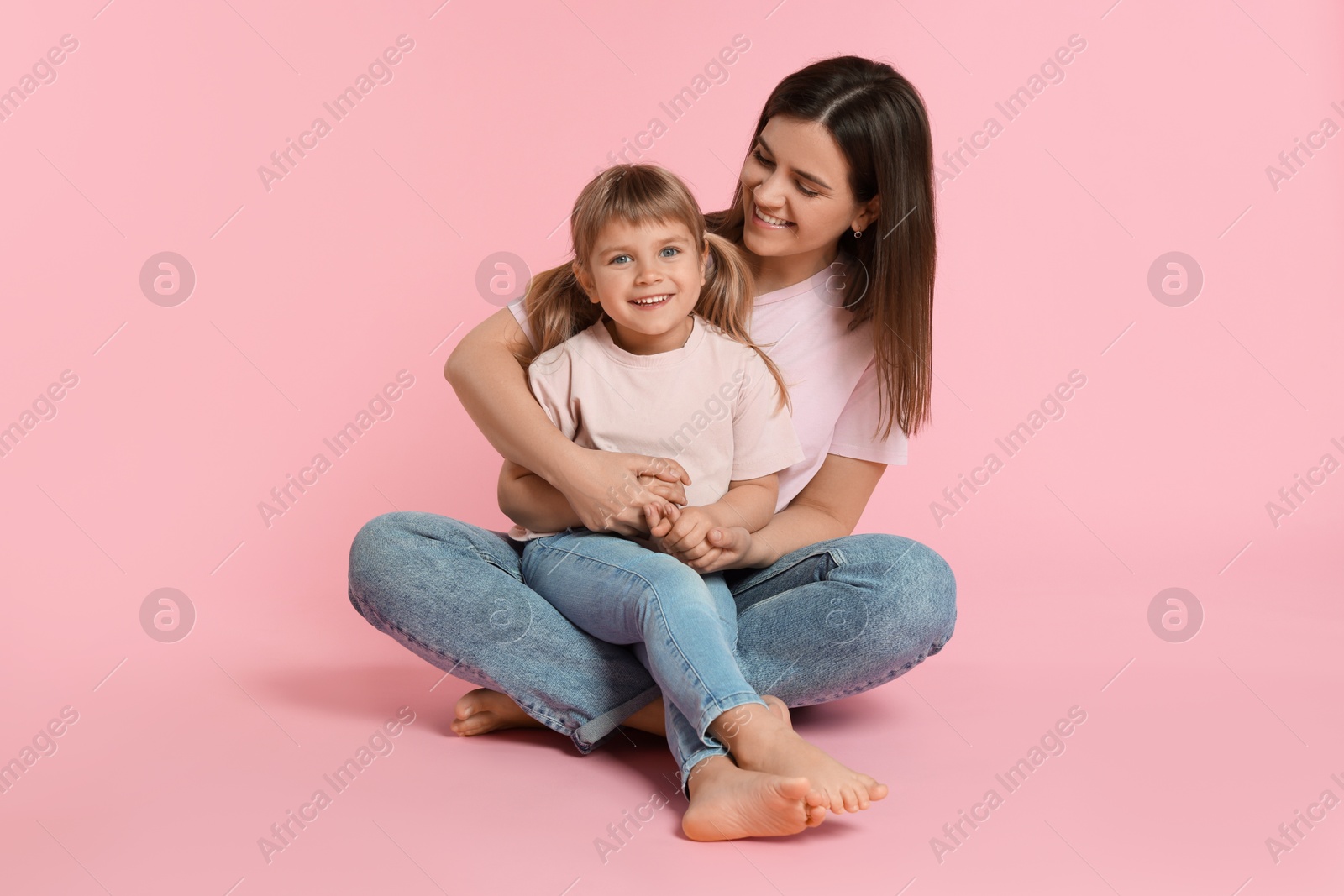 Photo of Happy mother and her cute daughter on pink background