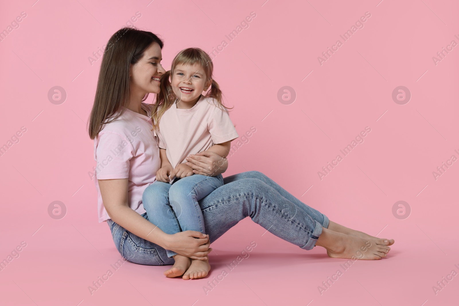 Photo of Happy mother and her cute daughter on pink background