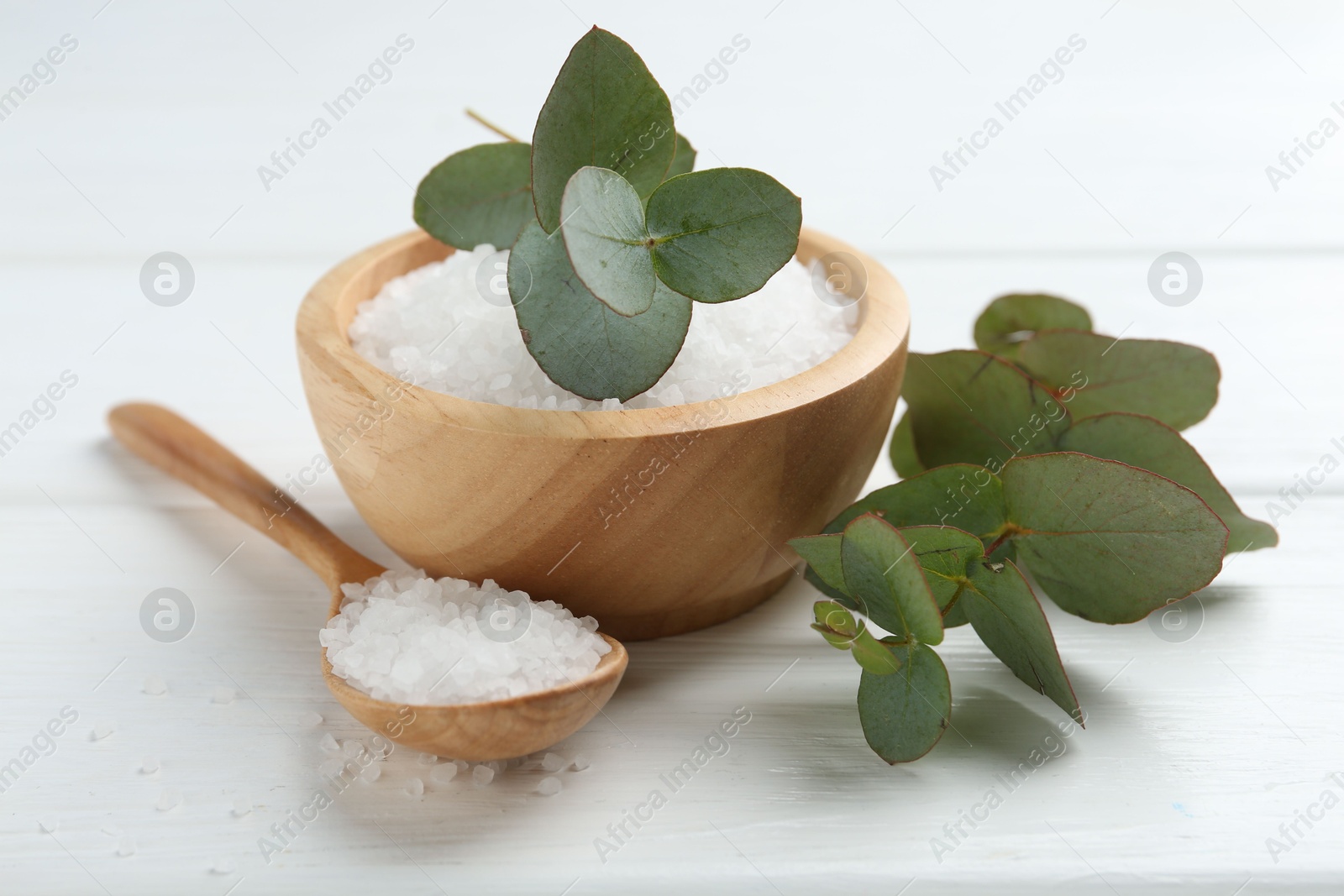 Sea salt and beautiful eucalyptus branches on white wooden table, closeup Photo of Sea salt and beautiful eucalyptus branches on white wooden table, closeup