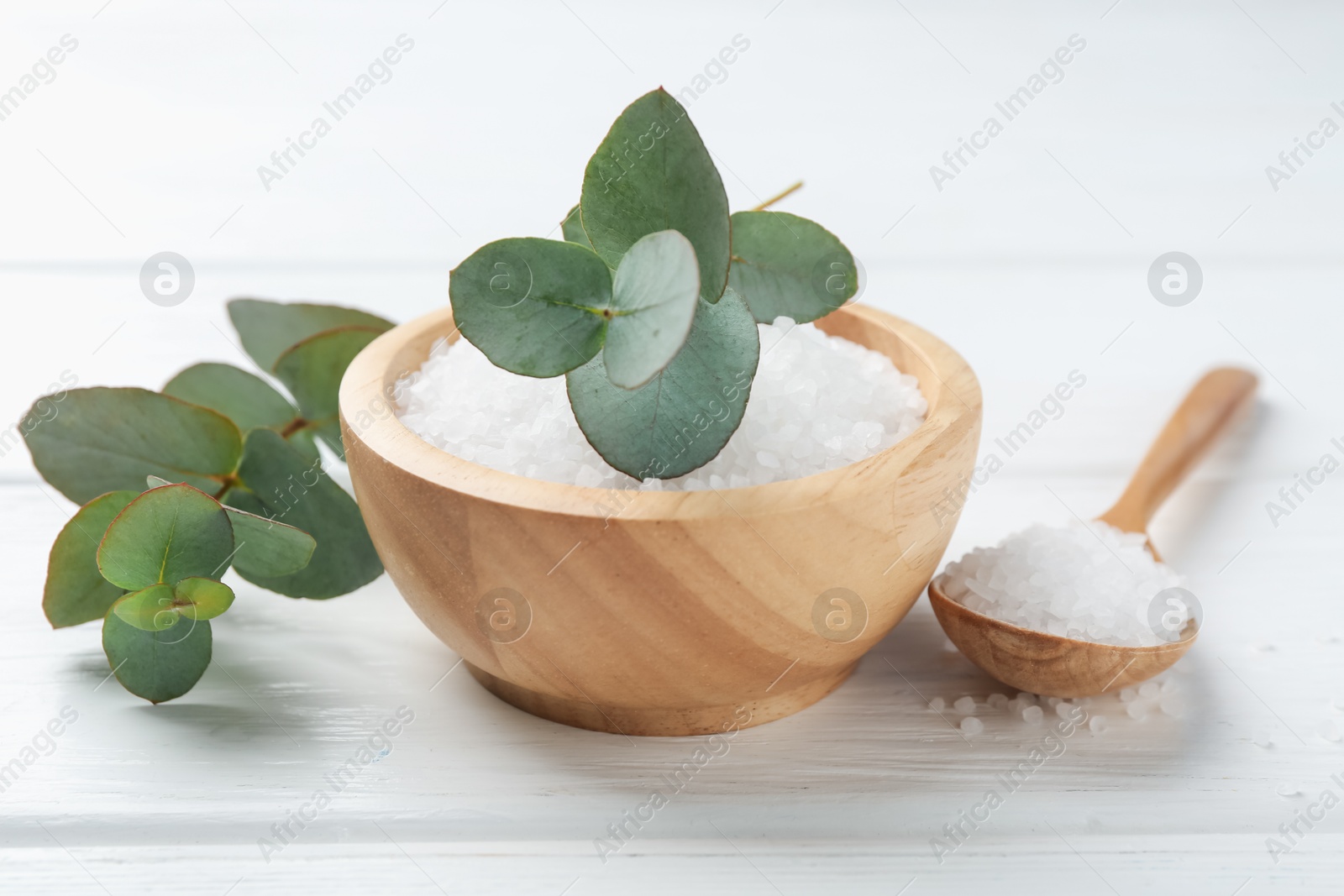 Sea salt and beautiful eucalyptus branches on white wooden table, closeup Photo of Sea salt and beautiful eucalyptus branches on white wooden table, closeup