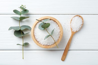 Photo of Sea salt and beautiful eucalyptus branches on white wooden table, flat lay