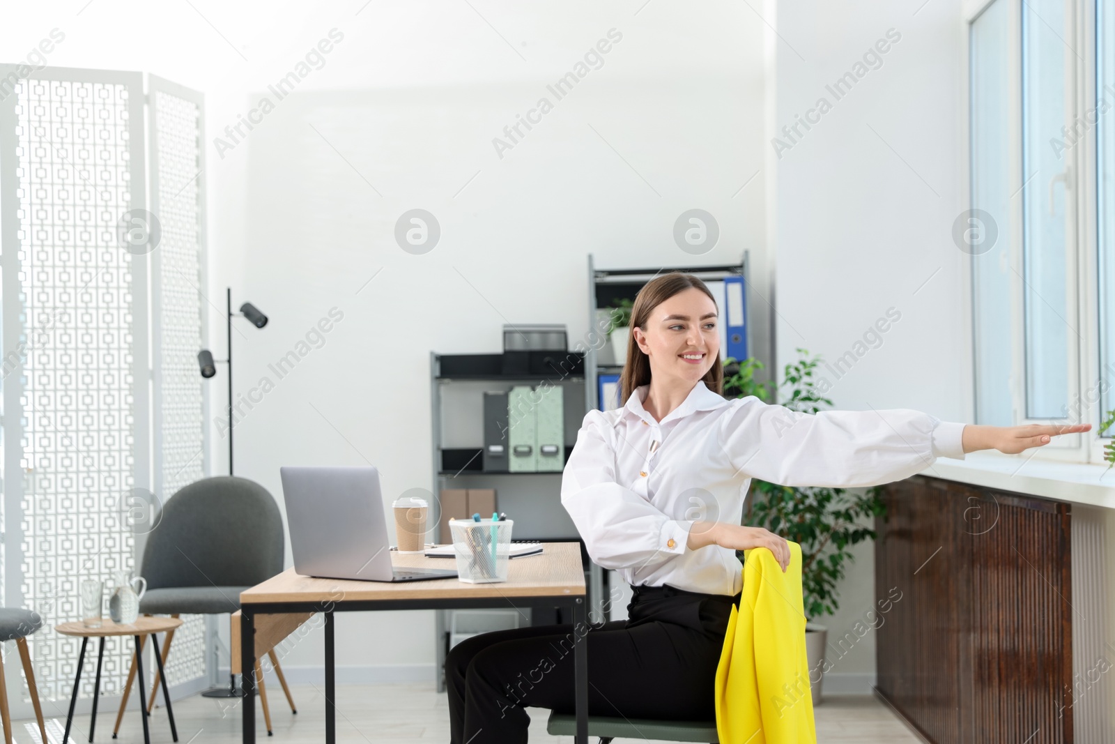 Beautiful woman stretching on chair in office Photo of Beautiful woman stretching on chair in office