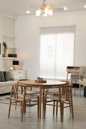Photo of Table, chairs and comfortable sofa indoors. Interior design