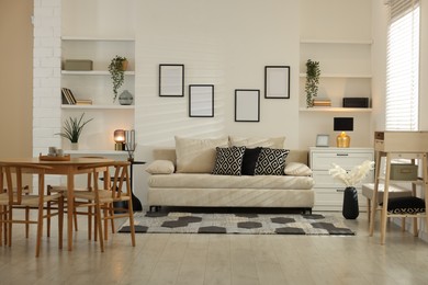 Photo of Comfortable sofa, table, chairs and dresser indoors. Interior design