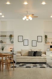 Photo of Comfortable sofa, table, chairs and dresser indoors. Interior design
