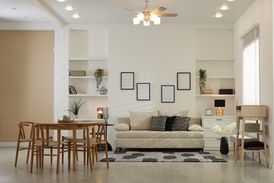 Photo of Comfortable sofa, table, chairs and dresser indoors. Interior design